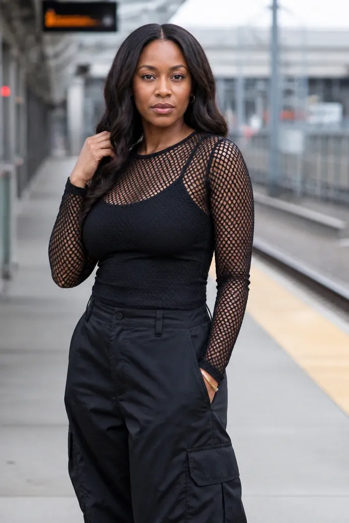 Black mesh long-sleeve top over a cami with baggy cargo pants