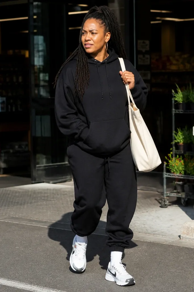 Black hoodie with tapered baggy sweatpants and white sneakers with visible socks