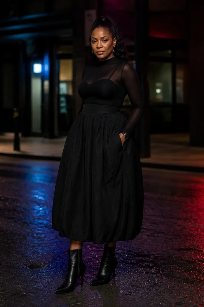 Black midi bubble skirt with sheer black long-sleeve top and sleek ankle boots