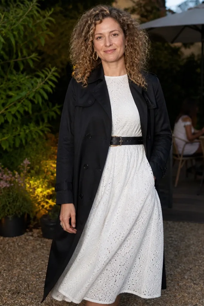 White eyelet dress with black trench coat and black belt