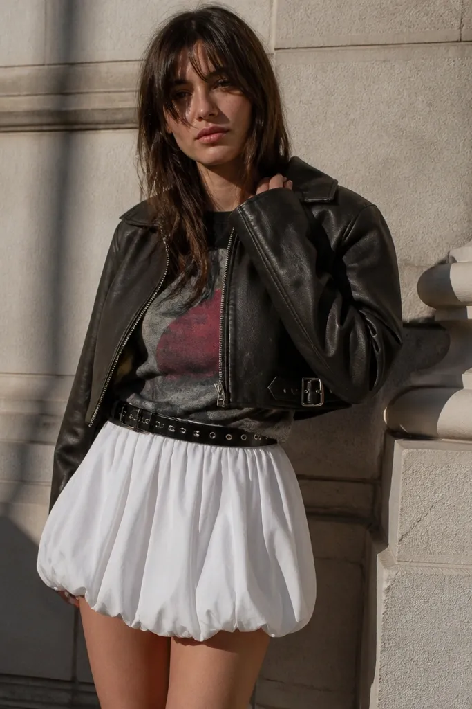 Graphic tee tucked into a white bubble skirt with a cropped leather jacket
